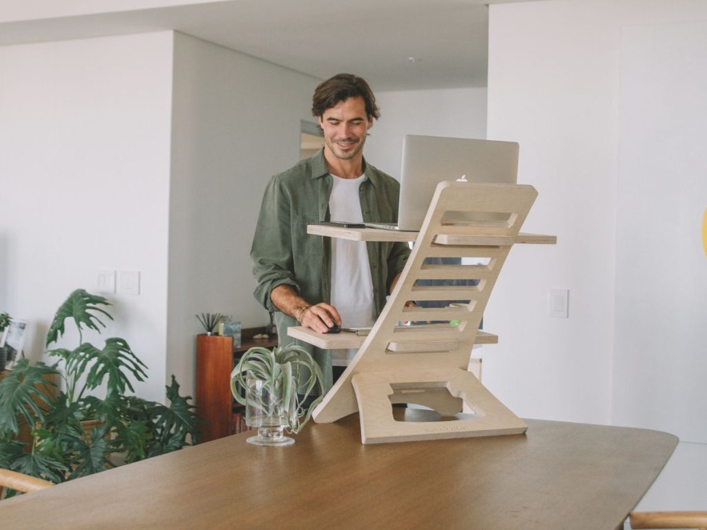 man working on standing desk converter